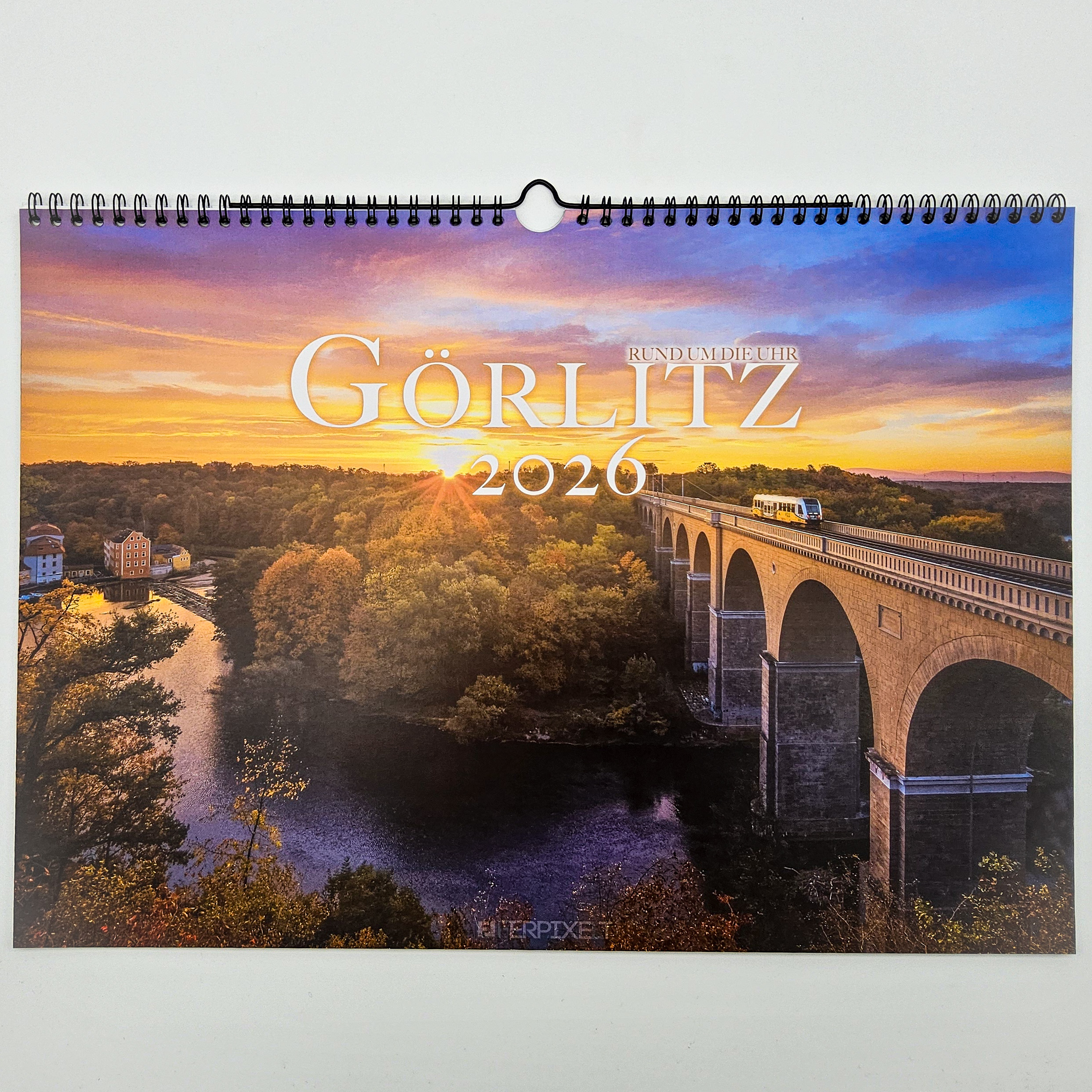 Auf dem Titelbild des Kalenders Görlitz Rund um die Uhr ist der Sonnenaufgang am Viadukt zu sehen.