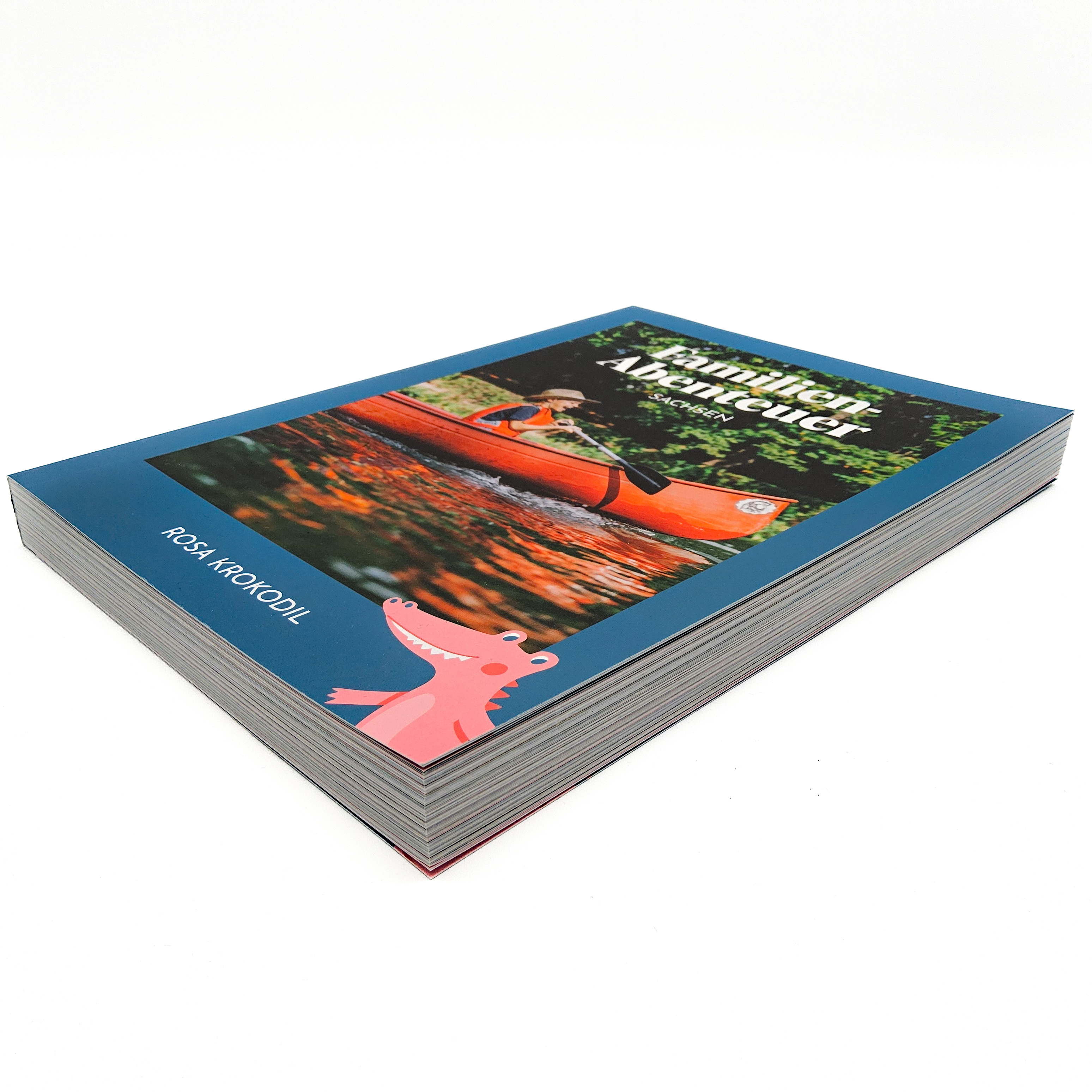 Das Buch Familien Abenteuer mit dem Rosa Krokodil liegt auf weißem Untergrund. Man erkennt,wie dick das Buch ist.