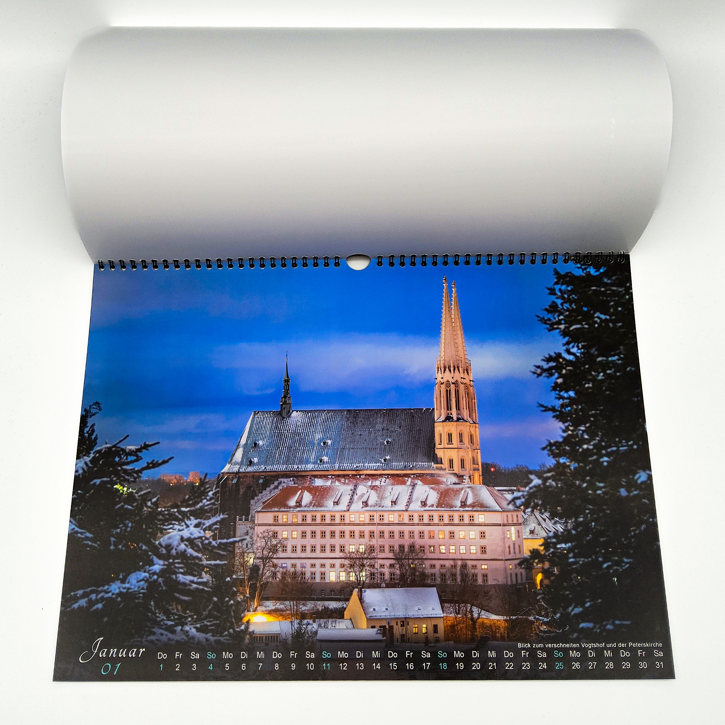 Der Kalender ist aufgeblättert und man sieht das Motiv vom Januar. Hier ist die Peterkirche mit dem Vogtshof im Vordergrund zu erkennen. Etwas Schnee auf den Dächern erzeugt eine schöne winterliche Stimmung.