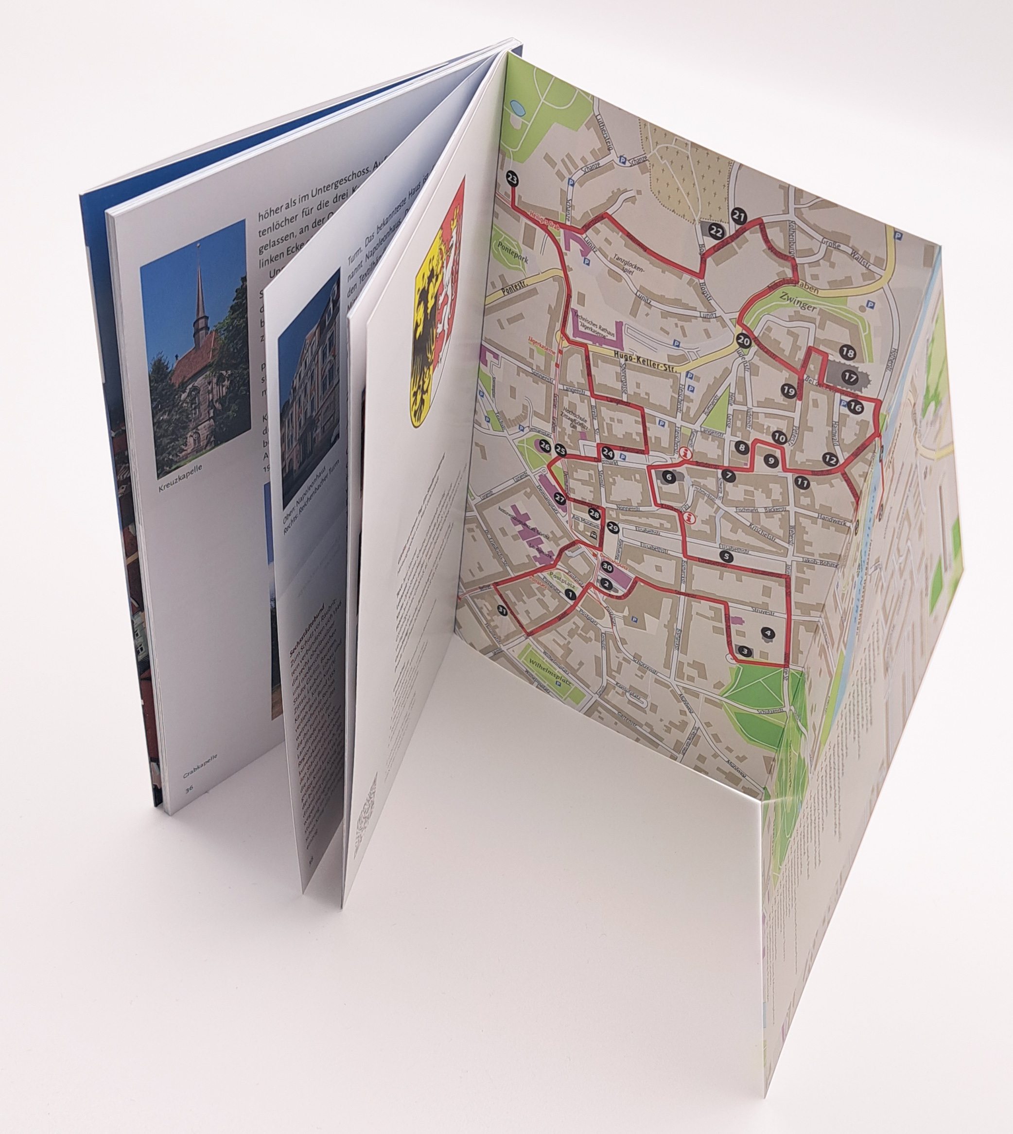 Der Stadtführer ist aufgestellt und die letzte Seite sogar aufgeklappt. Man erkennt, den Stadtplan auf der aufgeklappten Doppelseite und sieht ein paar Innenseiten.