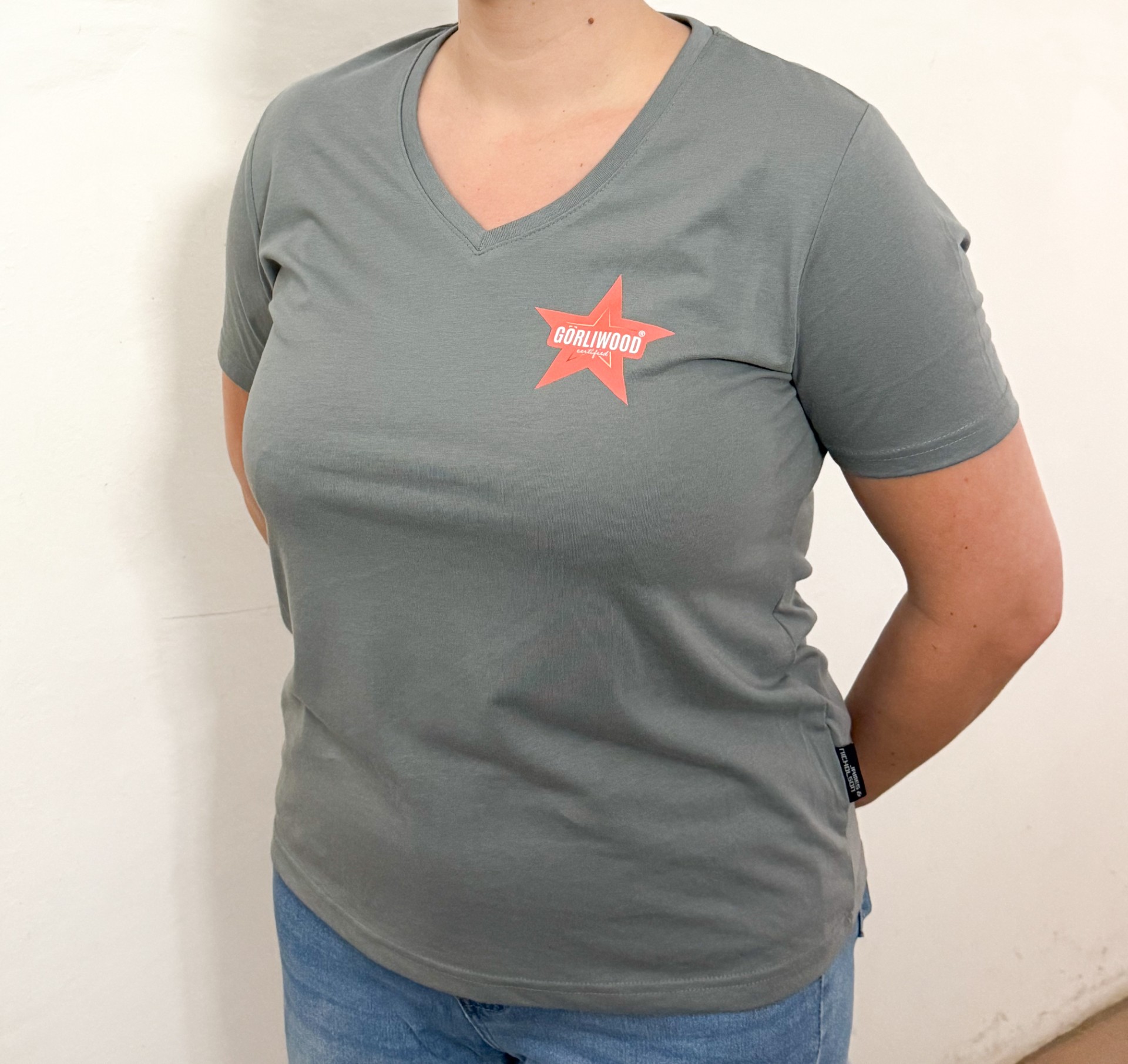 Die Vorderseite des grauen Damen Shirts hat einen V-Ausschnitt und links auf der Brust den Görliwood- Stern.