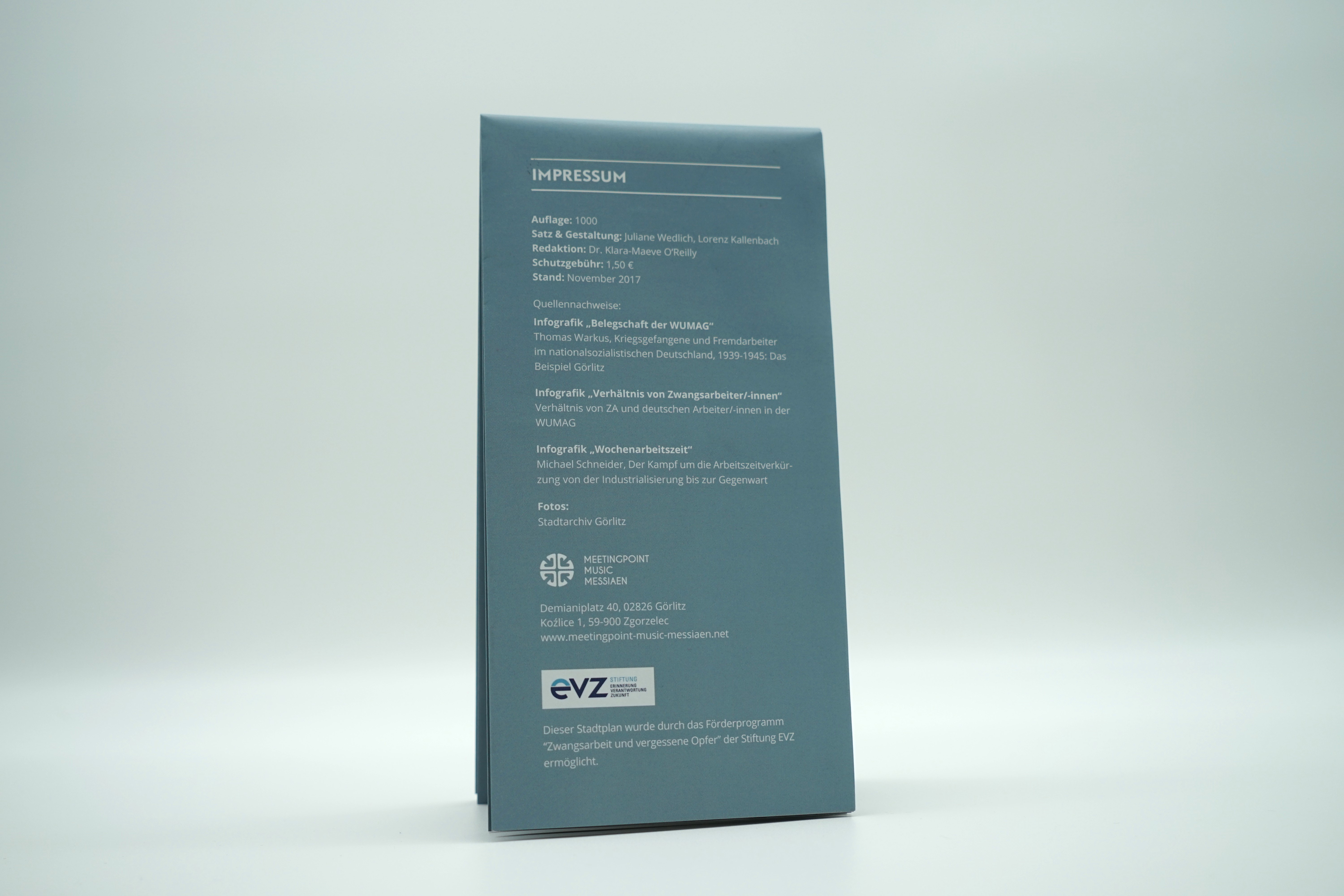 Auf der Rückseite kann man die weiße Schrift auf grau-blauem Hintergrund lesen